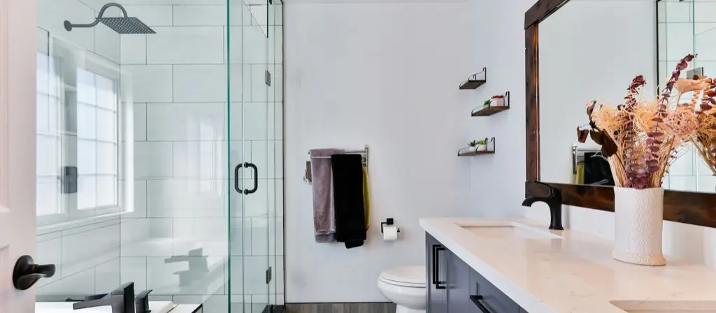 A clean modern bathroom with a glass shower and a wide vanity.
